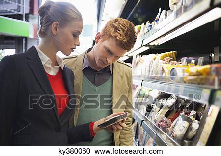 Couple shopping in a supermarket View Large Photo Image Stock Image - Couple shopping in a supermarket. Fotosearch