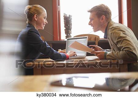 Couple sitting in a restaurant working on a laptop View Large Photo Image Picture - Couple sitting in a restaurant working on a laptop. Fotosearch