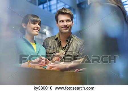 Happy couple standing at a bank counter View Large Photo Image Stock Image - Happy couple standing at a bank counter. Fotosearch