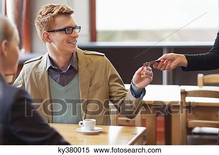 Stock Photography - Man paying bill by credit card in a restaurant. Fotosearch