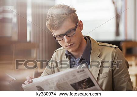 Man sitting in a restaurant and reading a newspaper View Large Photo Image Picture - Man sitting in a restaurant and reading a newspaper. Fotosearch