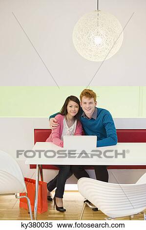 Portrait of a business couple working on a laptop in an office View Large Photo Image Stock Photography - Portrait of a business couple working on a laptop in an office. Fotosearch