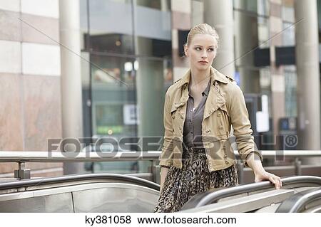 Businesswoman standing on escalator View Large Photo Image Stock Photo - Businesswoman standing on escalator. Fotosearch