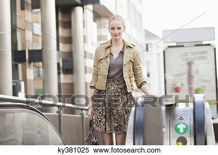 Stock Photography - Businesswoman standing on escalator. Fotosearch