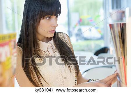Close-up of a woman choosing book from a bookshelf View Large Photo Image Stock Photo - Close-up of a woman choosing book from a bookshelf. Fotosearch