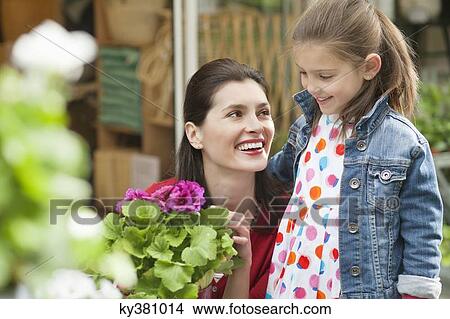 Woman and her daughter looking at flowers in a flower shop View Large Photo Image Picture - Woman and her daughter looking at flowers in a flower shop. Fotosearch
