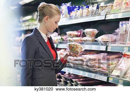 Woman shopping in a supermarket View Large Photo Image Stock Image - Woman shopping in a supermarket. Fotosearch