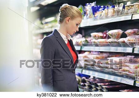 Woman shopping in a supermarket View Large Photo Image Stock Image - Woman shopping in a supermarket. Fotosearch
