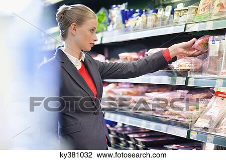 Woman shopping in a supermarket View Large Photo Image Stock Image - Woman shopping in a supermarket. Fotosearch