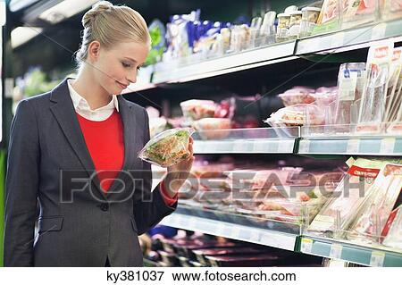Woman shopping in a supermarket View Large Photo Image Stock Photo - Woman shopping in a supermarket. Fotosearch