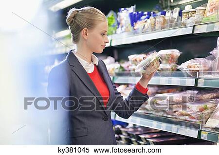 Woman shopping in a supermarket View Large Photo Image Stock Photography - Woman shopping in a supermarket. Fotosearch