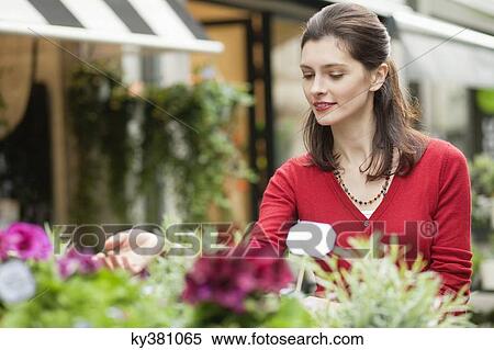 Woman touching flowers in a flower shop View Large Photo Image Stock Photography - Woman touching flowers in a flower shop. Fotosearch