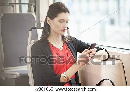 Woman traveling in a bus and using a mobile phone View Large Photo Image Stock Photograph - Woman traveling in a bus and using a mobile phone. Fotosearch