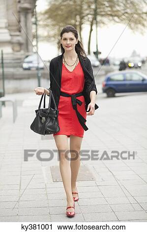 Stock Image - Woman walking on street. Fotosearch