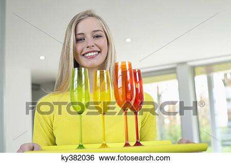 Happy woman carrying glasses on a tray View Large Photo Image Stock Photograph - Happy woman carrying glasses on a tray. Fotosearch