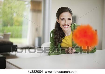 Picture - Happy woman holding a feather duster. Fotosearch
