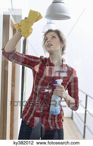 Stock Image - Woman cleaning a glass door. Fotosearch