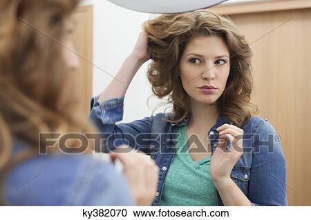 Stock Image - Woman examining her hair. Fotosearch
