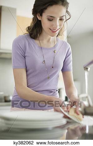 Woman washing dishes in the kitchen View Large Photo Image Stock Image - Woman washing dishes in the kitchen. Fotosearch