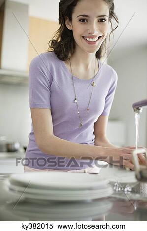 Stock Photography - Woman washing dishes in the kitchen. Fotosearch