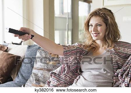Woman watching television in a living room View Large Photo Image Stock Photograph - Woman watching television in a living room. Fotosearch