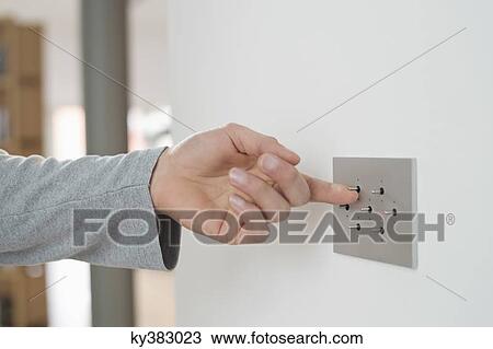 Close-up of a man's hand pressing light switch on a wall View Large Photo Image Stock Image - Close-up of a man's hand pressing light switch on a wall. Fotosearch