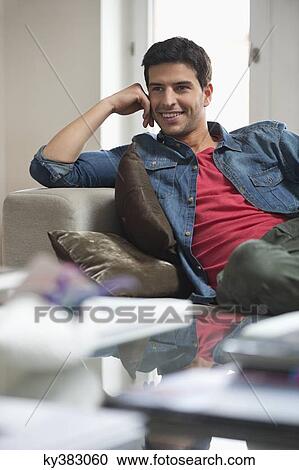 Happy man reclining on a couch View Large Photo Image Stock Image - Happy man reclining on a couch. Fotosearch