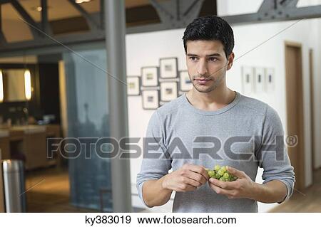 Man eating grapes View Large Photo Image Stock Photo - Man eating grapes. Fotosearch