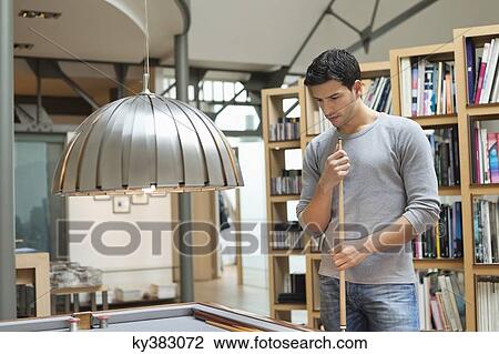 Stock Image - Man looking at a pool table. Fotosearch