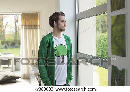 Man looking through a window View Large Photo Image Stock Image - Man looking through a window. Fotosearch