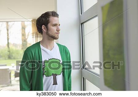 Man looking through a window View Large Photo Image Stock Image - Man looking through a window. Fotosearch