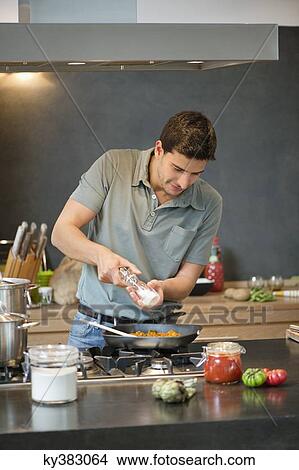 Picture - Man preparing food in the kitchen. Fotosearch