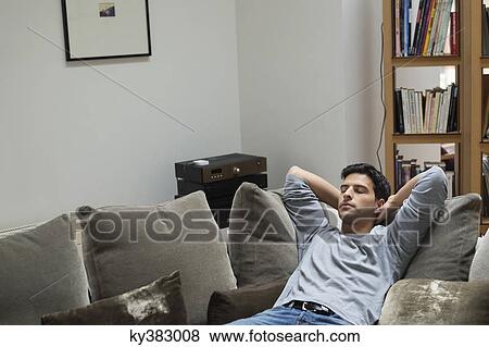 Man reclining on a couch View Large Photo Image Stock Photo - Man reclining on a couch. Fotosearch