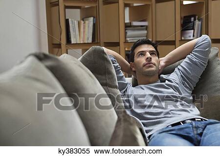 Stock Photography - Man reclining on a couch. Fotosearch