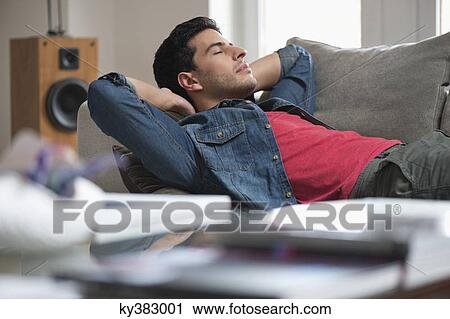 Man resting on a couch View Large Photo Image Stock Image - Man resting on a couch. Fotosearch