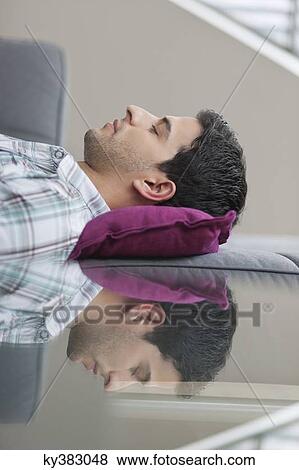 Stock Photo - Man sleeping on a couch. Fotosearch