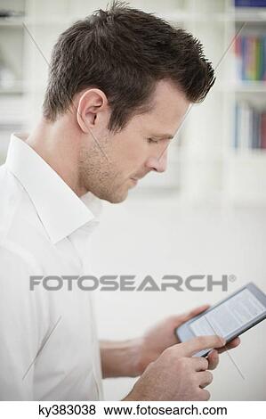 Man using an electronic book View Large Photo Image Stock Photo - Man using an electronic book. Fotosearch