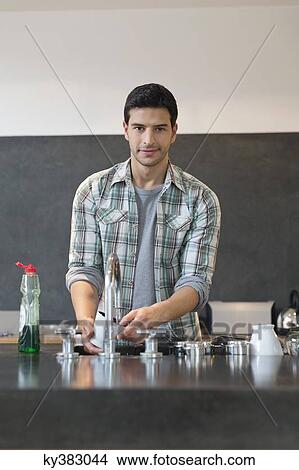 Picture - Man washing dishes in the kitchen. Fotosearch