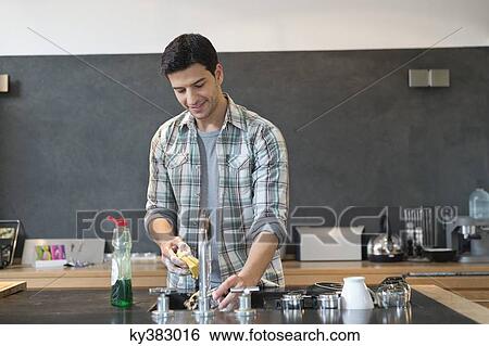 Man washing dishes in the kitchen View Large Photo Image Stock Photograph - Man washing dishes in the kitchen. Fotosearch