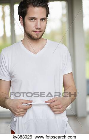 Stock Photograph - Portrait of a man holding a white shirt. Fotosearch