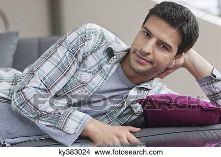 Portrait of a man lying on a couch View Large Photo Image Picture - Portrait of a man lying on a couch. Fotosearch