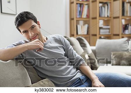 Stock Image - Portrait of a man resting on a couch. Fotosearch