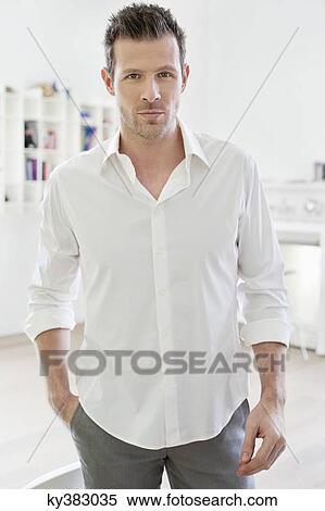 Portrait of a man standing with his hand in his pocket View Large Photo Image Stock Photography - Portrait of a man standing with his hand in his pocket. Fotosearch