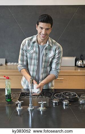 Portrait of a man washing dishes in the kitchen View Large Photo Image Stock Image - Portrait of a man washing dishes in the kitchen. Fotosearch