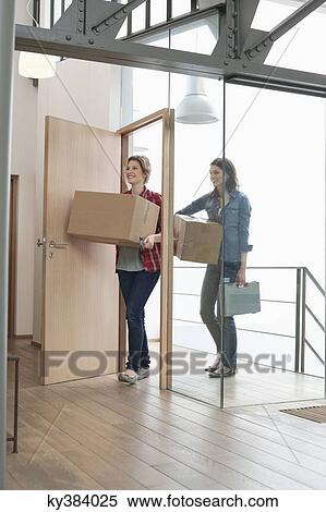 Female friends carrying cardboard boxes at home View Large Photo Image Stock Photography - Female friends carrying cardboard boxes at home. Fotosearch
