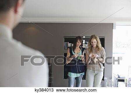Man looking at two women knitting View Large Photo Image Stock Image - Man looking at two women knitting. Fotosearch