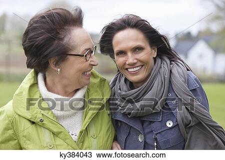 Two women laughing in park View Large Photo Image Stock Image - Two women laughing in park. Fotosearch