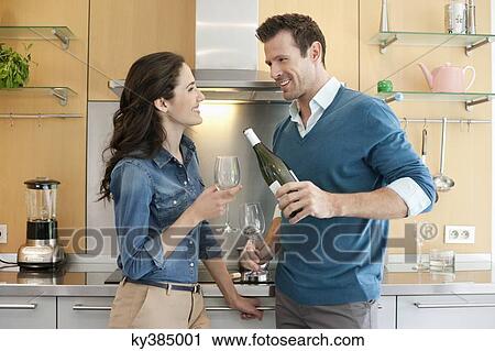 Couple drinking wine in the kitchen View Large Photo Image Stock Image - Couple drinking wine in the kitchen. Fotosearch