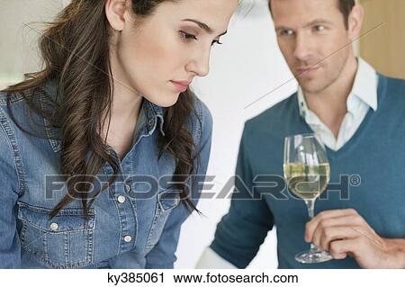 Stock Image - Couple drinking wine in the kitchen. Fotosearch