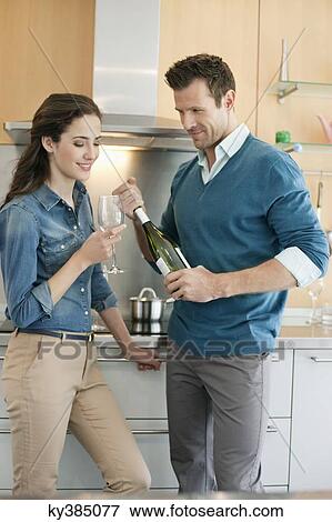 Couple drinking wine in the kitchen View Large Photo Image Stock Photo - Couple drinking wine in the kitchen. Fotosearch